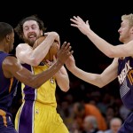 Los Angeles Lakers forward Ryan Kelly, middle, grabs a loose ball between Phoenix Suns guard Ronnie Price, left, and forward Chase Budinger during the first half of an NBA basketball game in Los Angeles, Friday, March 18, 2016. (AP Photo/Chris Carlson)