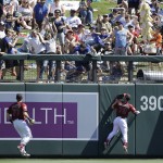 Arizona Diamondbacks center fielder Evan Marzilli (77) and right fielder Zach Borenstein (79) look up as fans reach for a 2-run home run hit by Los Angeles Dodgers' Yasmani Grandal during the first inning of a spring training baseball game in Scottsdale, Ariz., Friday, March 18, 2016. (AP Photo/Jeff Chiu)