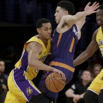 Los Angeles Lakers guard Jordan Clarkson, left, collides with Phoenix Suns guard Devin Booker during the first half of an NBA basketball game in Los Angeles, Friday, March 18, 2016. (AP Photo/Chris Carlson)