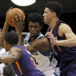 Minnesota Timberwolves guard Andrew Wiggins, center, splits the defense of Phoenix Suns guard Devin Booker, right, and Brandon Knight, left, during the first half of an NBA basketball game in Minneapolis, Monday, March 28, 2016. (AP Photo/Ann Heisenfelt)