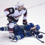 Arizona Coyotes defenseman Klas Dahlbeck (34) puts Vancouver Canucks right wing Jake Virtanen (18) to the ice during the first period of an NHL hockey game Wednesday, March 9, 2016, in Vancouver, British Columbia. (Jonathan Hayward/The Canadian Press via AP)