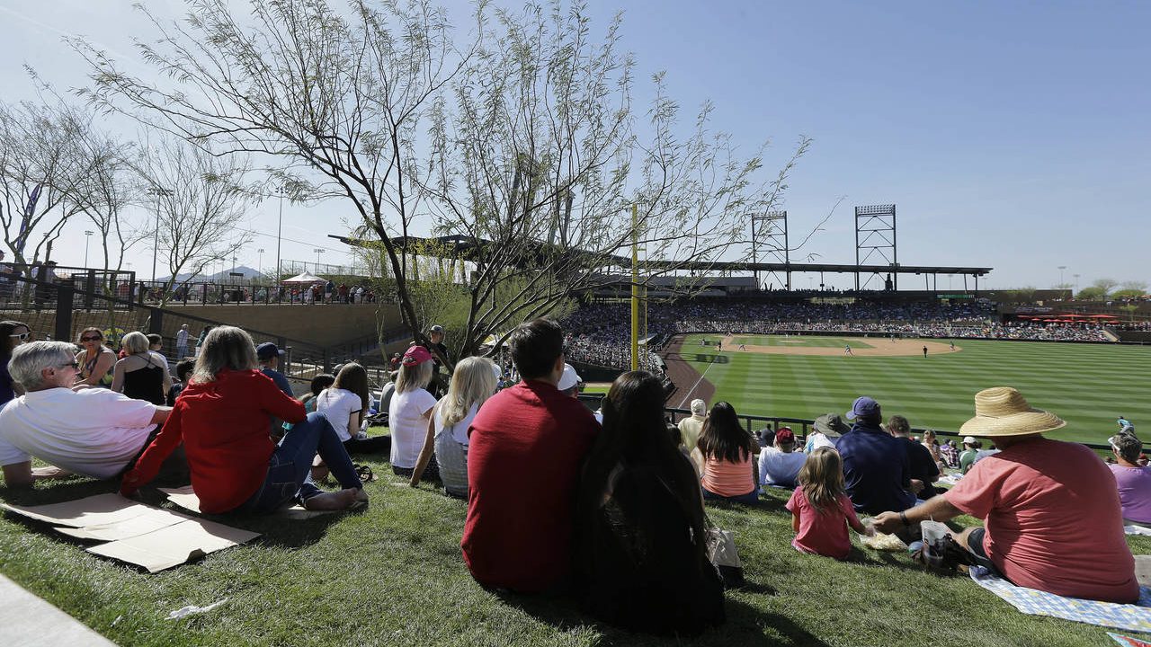 Fans watch a spring training baseball game between the Arizona Diamondbacks and the Seattle Mariner...