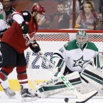 Arizona Coyotes' Tobias Rieder (8), of Germany, deflects a shot before it gets past Dallas Stars' Kari Lehtonen (32), of Finland, for a goal as Stars' Stephen Johns (28) looks on during the first period of an NHL hockey game, Thursday, March 24, 2016, in Glendale, Ariz. (AP Photo/Ross D. Franklin)