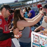 Arizona Diamondbacks' A.J. Pollock, left, smiles while while signing autographs for fans as as a fan takes a selfie with him prior to a spring training baseball game against the San Diego Padres, Tuesday, March 8, 2016, in Peoria, Ariz. (AP Photo/Ross D. Franklin)