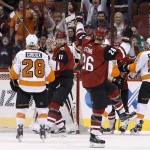Arizona Coyotes' Michael Stone (26) celebrates his goal as teammate Martin Hanzal (11), of the Czech Republic, smiles at Stone while Philadelphia Flyers' Claude Giroux (28) and Jakub Voracek (93), of the Czech Republic, look for the puck during the second period of an NHL hockey game Saturday, March 26, 2016, in Glendale, Ariz. (AP Photo/Ross D. Franklin)
