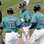 Seattle Mariners' Steve Clevenger (32), Stefen Romero (17) an Efren Navarro celebrate after scoring on a three-run single by Boog Powell during the second inning of a spring training baseball game against the Arizona Diamondbacks Monday, March 7, 2016, in Peoria, Ariz. (AP Photo/Charlie Riedel)