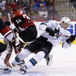 San Jose Sharks' Tomas Hertl, right, of the Czech Republic, falls to the ice as he collides with Arizona Coyotes' Mike Smith, left, and Klas Dahlbeck (34), of Sweden, during the first period of an NHL hockey game Thursday, March 17, 2016, in Glendale, Ariz. (AP Photo/Ross D. Franklin)