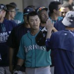 Seattle Mariners' Nori Aoki, from Japan, center, is congratulated by teammates after scoring against the Arizona Diamondbacks during the third inning of a spring training baseball game in Scottsdale, Ariz., Monday, March 14, 2016. (AP Photo/Jeff Chiu)