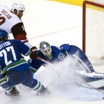 Vancouver Canucks defenseman Ben Hutton (27) tries to stop Arizona Coyotes left wing Anthony Duclair (10) from getting a shot on goalie Jacob Markstrom during the third period of an NHL hockey game Wednesday, March 9, 2016, in Vancouver, British Columbia. (Jonathan Hayward/The Canadian Press via AP) MANDATORY CREDIT