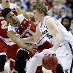 Wisconsin's Jordan Hill (11) tries to steal the ball from Xavier's J.P. Macura (55) during the first half of a second-round men's college basketball game against Wisconsin in the NCAA Tournament, Sunday, March 20, 2016, in St. Louis. (AP Photo/Charlie Riedel)