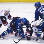 Vancouver Canucks center Bo Horvat (53) and Derek Dorsett (15) fight for control of the puck with Arizona Coyotes defenseman Klas Dahlbeck (34) and Antoine Vermette (50) during the third period of an NHL hockey game Wednesday, March 9, 2016, in Vancouver, British Columbia. (Jonathan Hayward/The Canadian Press via AP) MANDATORY CREDIT