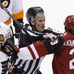 Linesman Greg Devorski, middle, tries to break up a scuffle between Arizona Coyotes' Oliver Ekman-Larsson (23), of Sweden, and Philadelphia Flyers' Jakub Voracek (93), of the Czech Republic, during the third period of an NHL hockey game Saturday, March 26, 2016, in Glendale, Ariz. The Coyotes defeated the Flyers 2-1. (AP Photo/Ross D. Franklin)