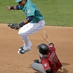 Seattle Mariners second baseman Robinson Cano leaps over Arizona Diamondbacks' Carlos Rivero (74) after Rivero was forced out at second on a fielders choice hit by Jason Bourgeois during the fourth inning of a spring training baseball game Monday, March 7, 2016, in Peoria, Ariz. (AP Photo/Charlie Riedel)