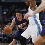Phoenix Suns guard Devin Booker, left, drives to the rim past Denver Nuggets forward Darrell Arthur in the first half of an NBA basketball game Thursday, March 10, 2016, in Denver. (AP Photo/David Zalubowski)