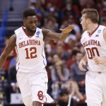 Oklahoma forward Khadeem Lattin (12) reaches out to slap hands with teammate Ryan Spangler (00) after a basket in the second half of a first-round men's college basketball game against Cal State Bakersfield in the NCAA Tournament, Friday, March 18, 2016, in Oklahoma City. Oklahoma won 82-68. (AP Photo/Sue Ogrocki)