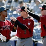 Arizona Diamondbacks' Jean Segura, left, is congratulated by manager Chip Hale (3) and pitching coach Mike Butcher (23) after scoring a run against the San Diego Padres during the second inning of a spring training baseball game Tuesday, March 8, 2016, in Peoria, Ariz. (AP Photo/Ross D. Franklin)