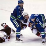 Arizona Coyotes center Antoine Vermette (50) looks on as Vancouver Canucks defenseman Dan Hamhuis (2) and Canucks defenseman Yannick Weber (6) take out Arizona Coyotes left wing Alex Tanguay (40) during the third period of an NHL hockey game Wednesday, March 9, 2016, in Vancouver, British Columbia. (Jonathan Hayward/The Canadian Press via AP) MANDATORY CREDIT