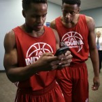 Indiana's Yogi Ferrell, left, and Troy Williams check scores on a cellphone following a news conference ahead of a second-round men's college basketball game in the NCAA Tournament, Friday, March 18, 2016, in Des Moines, Iowa. Indiana will play Kentucky on Saturday. (AP Photo/Charlie Neibergall)