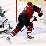Arizona Coyotes' Martin Hanzal, right, of the Czech Republic, scores a goal against Dallas Stars' Kari Lehtonen, left, of Finland, during the third period of an NHL hockey game Thursday, March 24, 2016, in Glendale, Ariz. Hanzal scored two goals on the night, his 100th and 101st NHL goals, as the Coyotes defeated the Stars 3-1. (AP Photo/Ross D. Franklin)