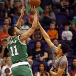 Boston Celtics guard Evan Turner, left, shoots over Phoenix Suns guard John Jenkins, right, in the first quarter during an NBA basketball game, Saturday, March 26, 2016, in Phoenix. (AP Photo/Rick Scuteri)