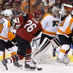 Arizona Coyotes' Michael Stone (26) sends the puck past Philadelphia Flyers goalie Steve Mason, middle, for a goal as Flyers' Brandon Manning (23) tangles with Coyotes' Max Domi (16), while Flyers' Claude Giroux (28) watches during the second period of an NHL hockey game Saturday, March 26, 2016, in Glendale, Ariz. (AP Photo/Ross D. Franklin)