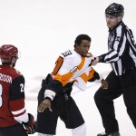 Philadelphia Flyers' Wayne Simmonds (17) is restrained by linesman Greg Devorski (54) as he tries to go after Arizona Coyotes' Oliver Ekman-Larsson (23), of Sweden, during the third period of an NHL hockey game Saturday, March 26, 2016, in Glendale, Ariz. The Coyotes defeated the Flyers 2-1. (AP Photo/Ross D. Franklin)
