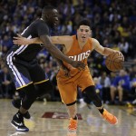 Phoenix Suns' Devin Booker, right, drives the ball against Golden State Warriors' Draymond Green during the second half of an NBA basketball game Saturday, March 12, 2016, in Oakland, Calif. (AP Photo/Ben Margot)