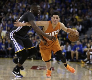 Phoenix Suns' Devin Booker, right, drives the ball against Golden State Warriors' Draymond Green during the second half of an NBA basketball game Saturday, March 12, 2016, in Oakland, Calif. (AP Photo/Ben Margot)
