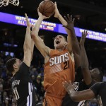 Phoenix Suns' Alex Len (21) shoots over Golden State Warriors' Klay Thompson, left, and Draymond Green (23) during the second half of an NBA basketball game Saturday, March 12, 2016, in Oakland, Calif. (AP Photo/Ben Margot)