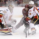 Calgary Flames' Joni Ortio (37), of Finland, gets sprayed as Arizona Coyotes' Antoine Vermette (50) battles for position with Flames' Mark Giordano (5) during the second period of an NHL hockey game Monday, March 28, 2016, in Glendale, Ariz. (AP Photo/Ross D. Franklin)