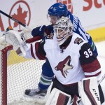 Vancouver Canucks right wing Jake Virtanen (18) goes into the net behind Arizona Coyotes goalie Louis Domingue (35) during the first period of an NHL hockey game Wednesday, March 9, 2016, in Vancouver, British Columbia. (Jonathan Hayward/The Canadian Press via AP)