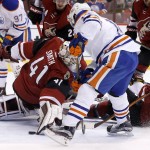 The puck gets past Arizona Coyotes' Mike Smith (41) as Edmonton Oilers' Jordan Eberle, middle, gets ready to score as Oilers' Nail Yakupov, right, of Russia, looks on during the first period of an NHL hockey game, Tuesday, March 22, 2016, in Glendale, Ariz. (AP Photo/Ross D. Franklin)