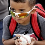A young fan waits for an autograph before a spring training baseball game between the Seattle Mariners and the Arizona Diamondbacks Monday, March 7, 2016, in Peoria, Ariz. (AP Photo/Charlie Riedel)