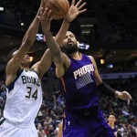 Phoenix Suns center Tyson Chandler, right, and Milwaukee Bucks forward Giannis Antetokounmpo, left, reach for the ball during the second half of an NBA basketball game Wednesday, March 30, 2016, in Milwaukee. (AP Photo/Darren Hauck)