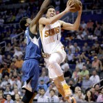 Phoenix Suns' Devin Booker (1) scores on Minnesota Timberwolves' Andrew Wiggins during the second half of an NBA basketball game, Monday, March 14, 2016, in Phoenix. The Suns won 107-104. (AP Photo/Matt York)