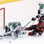 Arizona Coyotes' Brad Richardson (12) gets pulled down by Dallas Stars' Jamie Benn, top right, as he tries to get off a shot on Stars' Kari Lehtonen, left, of Finland, during the second period of an NHL hockey game Thursday, March 24, 2016, in Glendale, Ariz. The Stars' Benn was penalized on the play. (AP Photo/Ross D. Franklin)