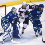 Vancouver Canucks defenseman Yannick Weber (6) and goalie Jacob Markstrom (25) and Arizona Coyotes right wing Shane Doan (19) look toward the puck during the second period of an NHL hockey game Wednesday, March 9, 2016, in Vancouver, British Columbia. (Jonathan Hayward/The Canadian Press via AP)