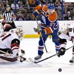 Arizona Coyotes' goalie Mike Smith (41) makes the save as teammate Zbynek Michalek (4) and Edmonton Oilers' Connor McDavid (97) battle for the puck during the second period of an NHL hockey game in Edmonton, Alberta, Saturday, March 12, 2016. (Jason Franson/The Canadian Press via AP) MANDATORY CREDIT