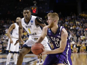 Stephen F. Austin's Thomas Walkup (0) drives past West Virginia's Jonathan Holton (1) during the second half of a first-round men's college basketball game in the NCAA Tournament,Friday, March 18, 2016, in New York. (AP Photo/Frank Franklin II)