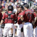 Arizona Diamondbacks pitcher Zack Greinke, center, meets on the mound with teammates during the third inning of a spring training baseball game against the Seattle Mariners in Scottsdale, Ariz., Monday, March 14, 2016. (AP Photo/Jeff Chiu)
