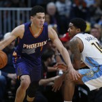 Phoenix Suns guard Devin Booker, left, drives past Denver Nuggets guard Gary Harris during the second half of an NBA basketball game Thursday, March 10, 2016, in Denver. The Nuggets won 116-98. (AP Photo/David Zalubowski)
