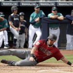 Arizona Diamondbacks' David Peralta slides home to score on a two-run double by Welington Castillo during the first inning of a spring training baseball game against the Seattle Mariners Monday, March 7, 2016, in Peoria, Ariz. (AP Photo/Charlie Riedel)
