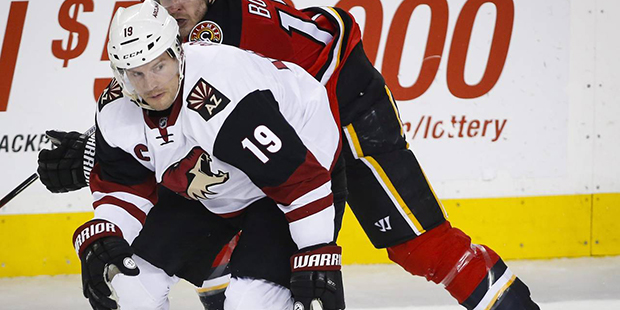 Arizona Coyotes' Shane Doan, left, and Calgary Flames' Lance Bouma chase the puck during the second...