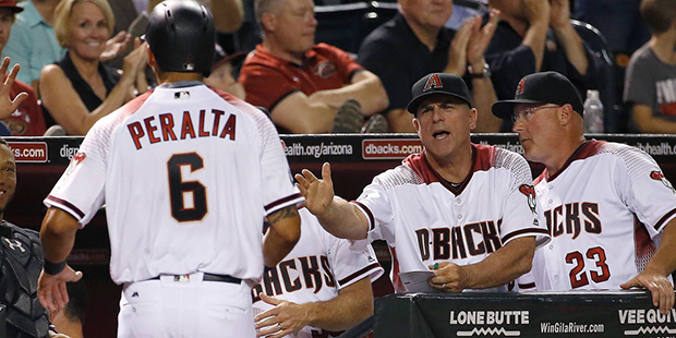 Arizona Diamondbacks left fielder David Peralta (6) is greeted at the dugout after scoring on an RB...