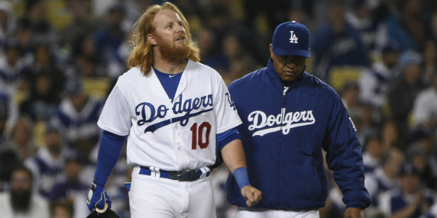 Los Angeles Dodgers' Justin Turner, left, walks to first base with manager David Roberts, right, af...