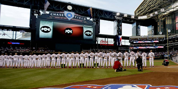 The Colorado Rockies and Arizona Diamondbacks line up during the National Anthem prior to a basebal...