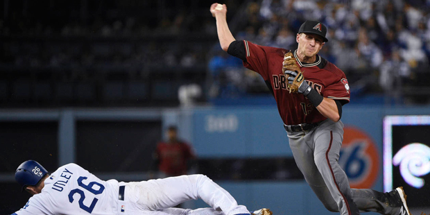 Arizona Diamondbacks shortstop Nick Ahmed, right, throws to first base after he forced out Los Ange...
