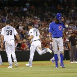 Chicago Cubs Dexter Fowler walks to the dugout after being caught in an inning-ending double play as Arizona Diamondbacks Robbie Ray (38), David Peralta (6) and Nick Ahmed (13) head to dugout during the fifth inning of a baseball game, Friday, April 8, 2016, in Phoenix. (AP Photo/Matt York)