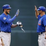 Chicago Cubs' Kris Bryant, left, gets a high-five from first base coach Brandon Hyde, right, after hitting a run-scoring double against the Arizona Diamondbacks during the first inning of a baseball game Saturday, April 9, 2016, in Phoenix. (AP Photo/Ross D. Franklin)