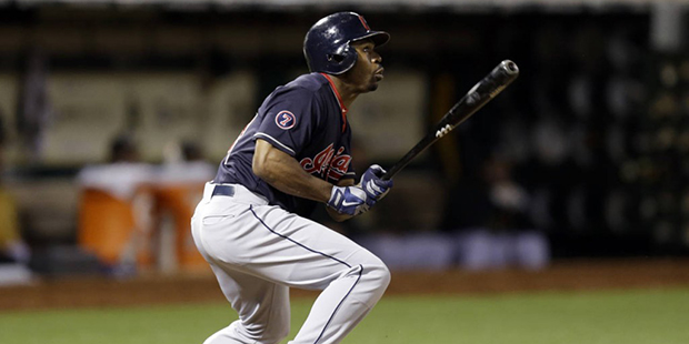 Cleveland Indians' Michael Bourn follows through on his RBI double against the Oakland Athletics' i...